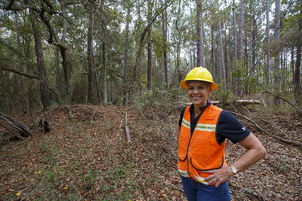 Terri stands in a forest