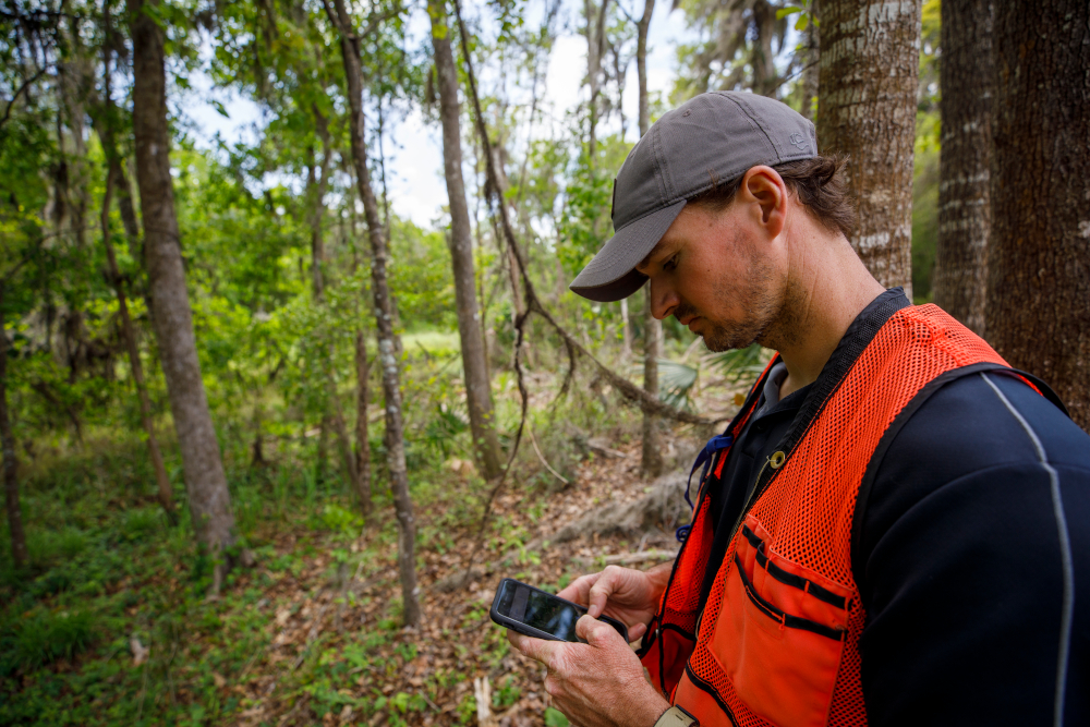 Wes checks his phone in the field