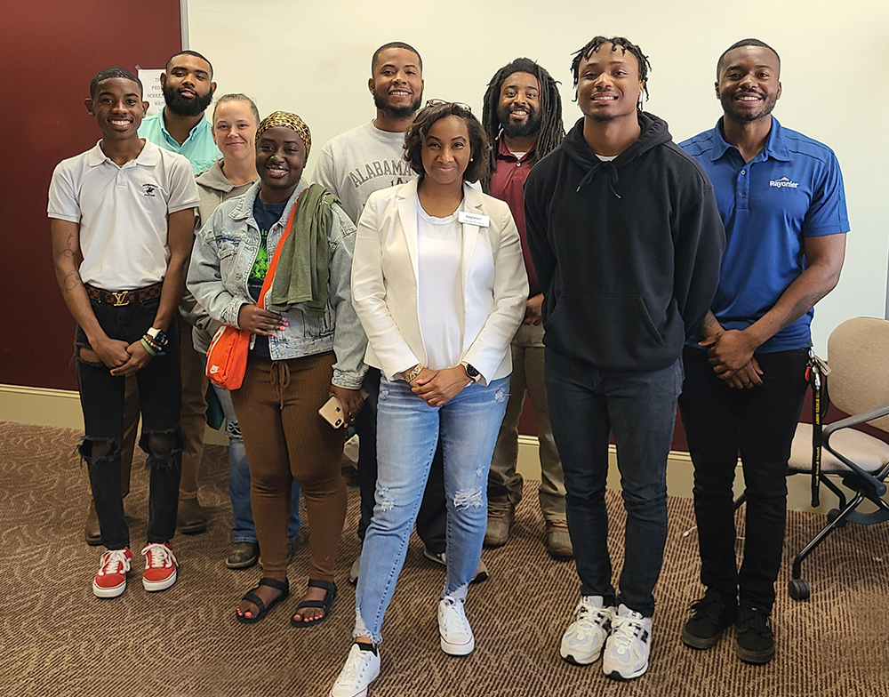Ebony stands in a group of people smiling at the camera